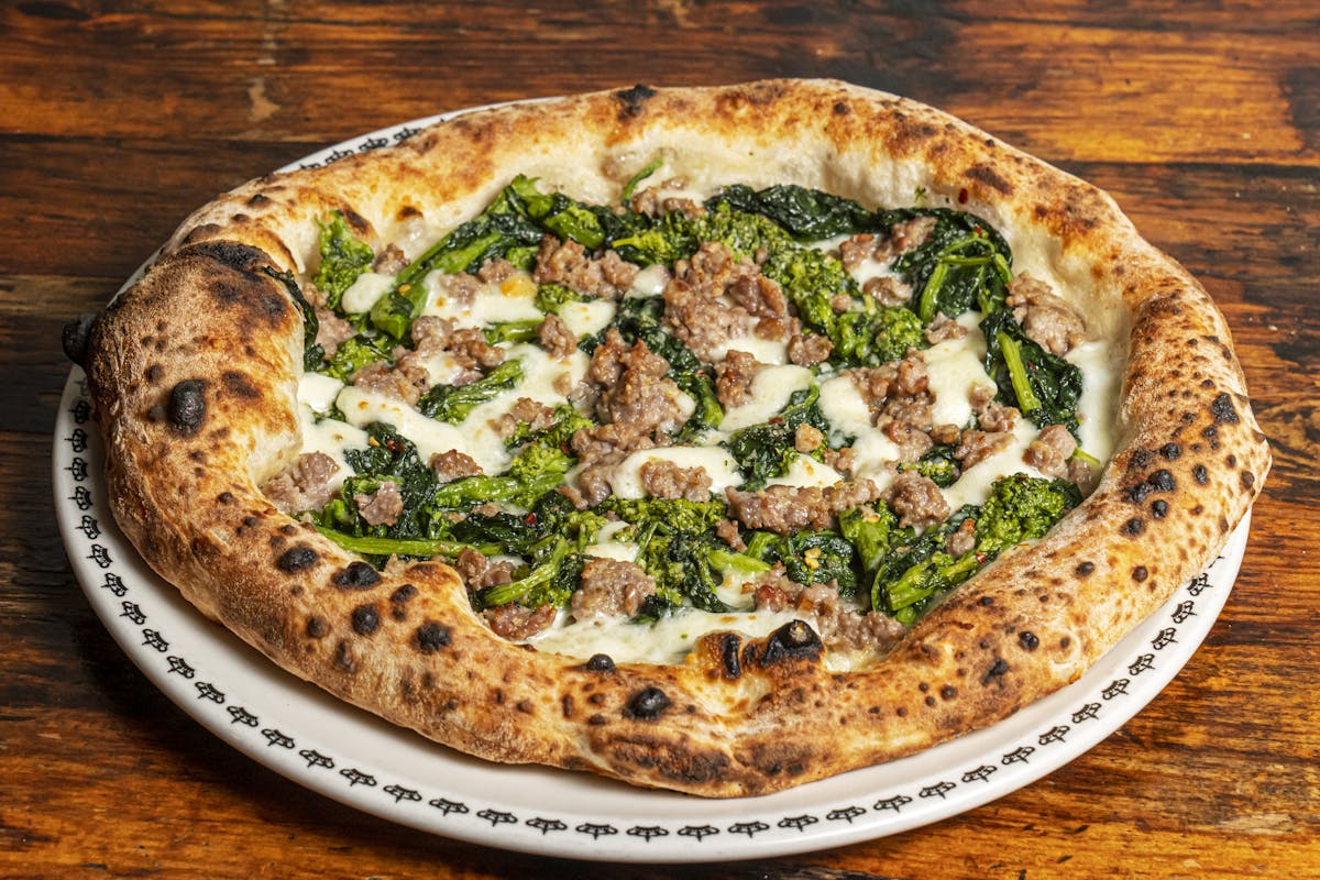 a pizza sitting on top of a wooden table